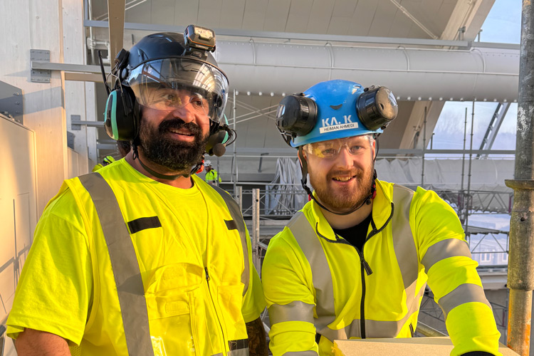 Två kollegor ler mot kameran